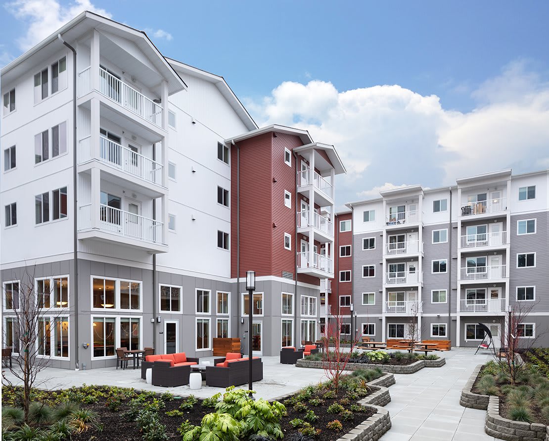 A modern apartment complex featuring a landscaped outdoor courtyard.