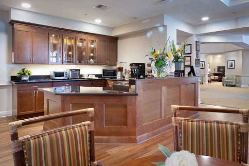 A beautifully designed modern kitchen featuring wooden cabinetry and vibrant floral arrangements.