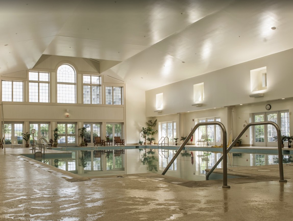 A luxurious indoor swimming pool with elegant architecture and ample natural light.