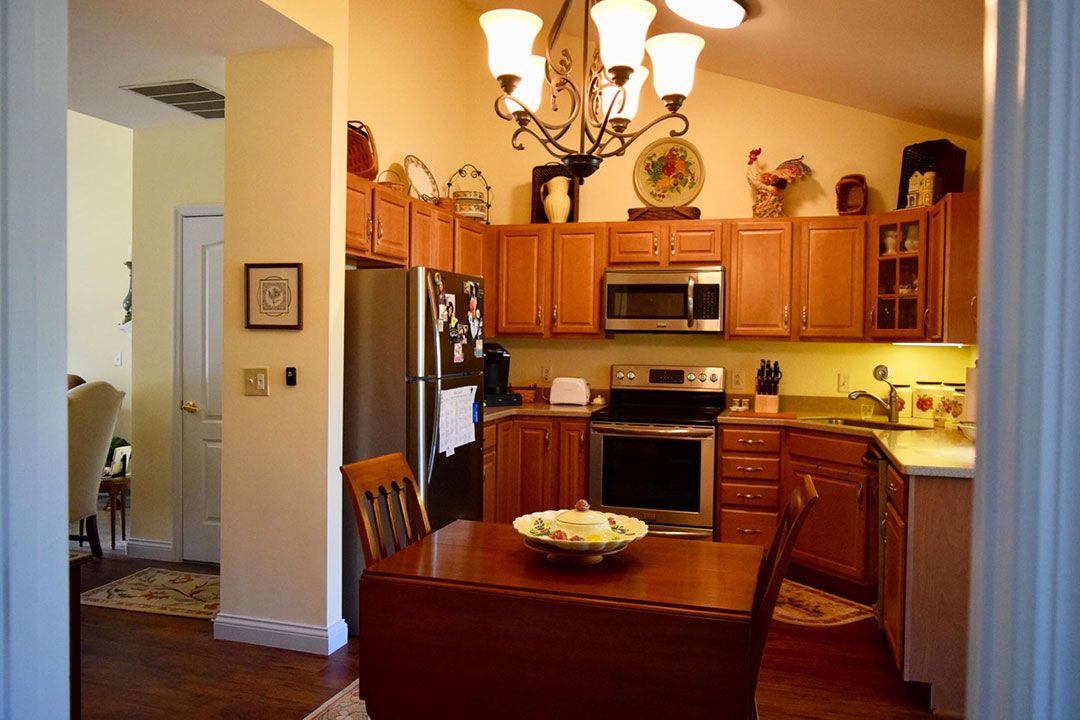 A cozy kitchen with wooden cabinets, a dining table, and modern appliances.