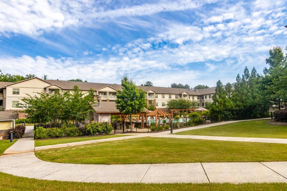 A scenic view of a landscaped area with a modern building and a clear blue sky.