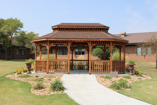 A beautifully designed wooden gazebo in a well-maintained garden, providing a serene outdoor space.