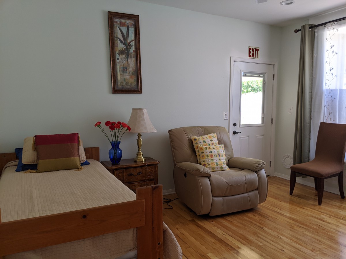 A cozy living room with a recliner, bed, and decorative elements.
