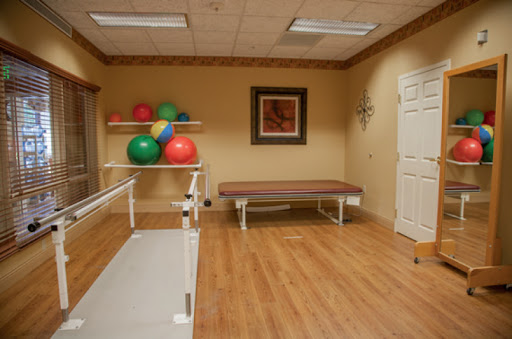 A well-equipped therapy room featuring exercise balls and a treatment table, designed for rehabilitation and physical therapy.