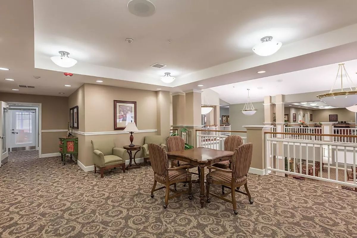A cozy interior room with a table, chairs, and elegant carpeting.