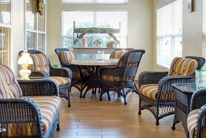 A cozy dining area with wicker furniture and plenty of natural light.