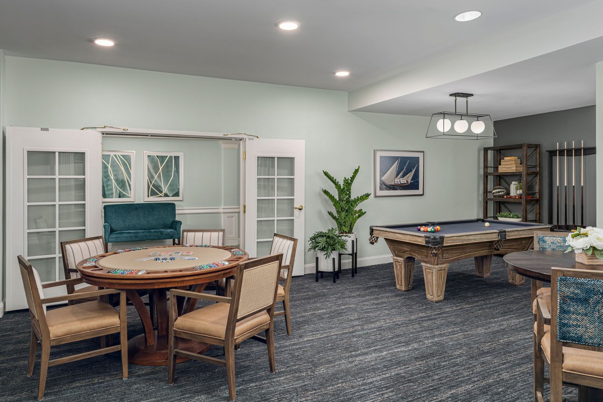 A cozy indoor game room featuring a pool table and board games setup.