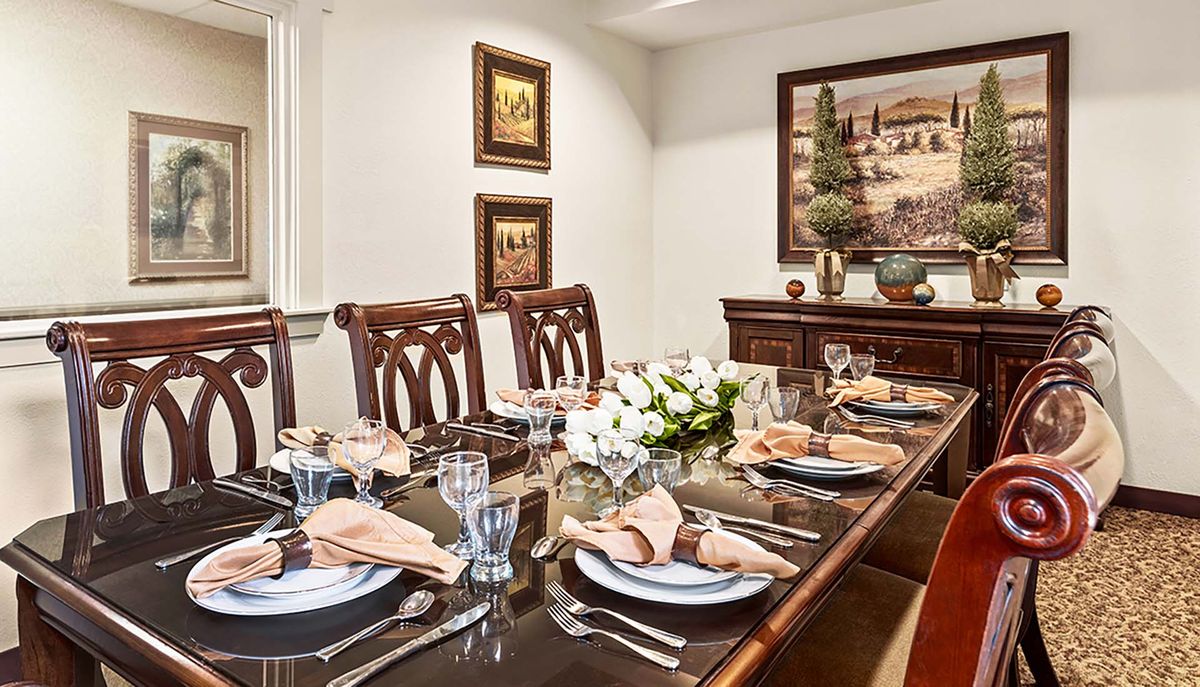An elegant dining room set for a formal dinner, featuring a beautifully arranged table with fine china and glassware.