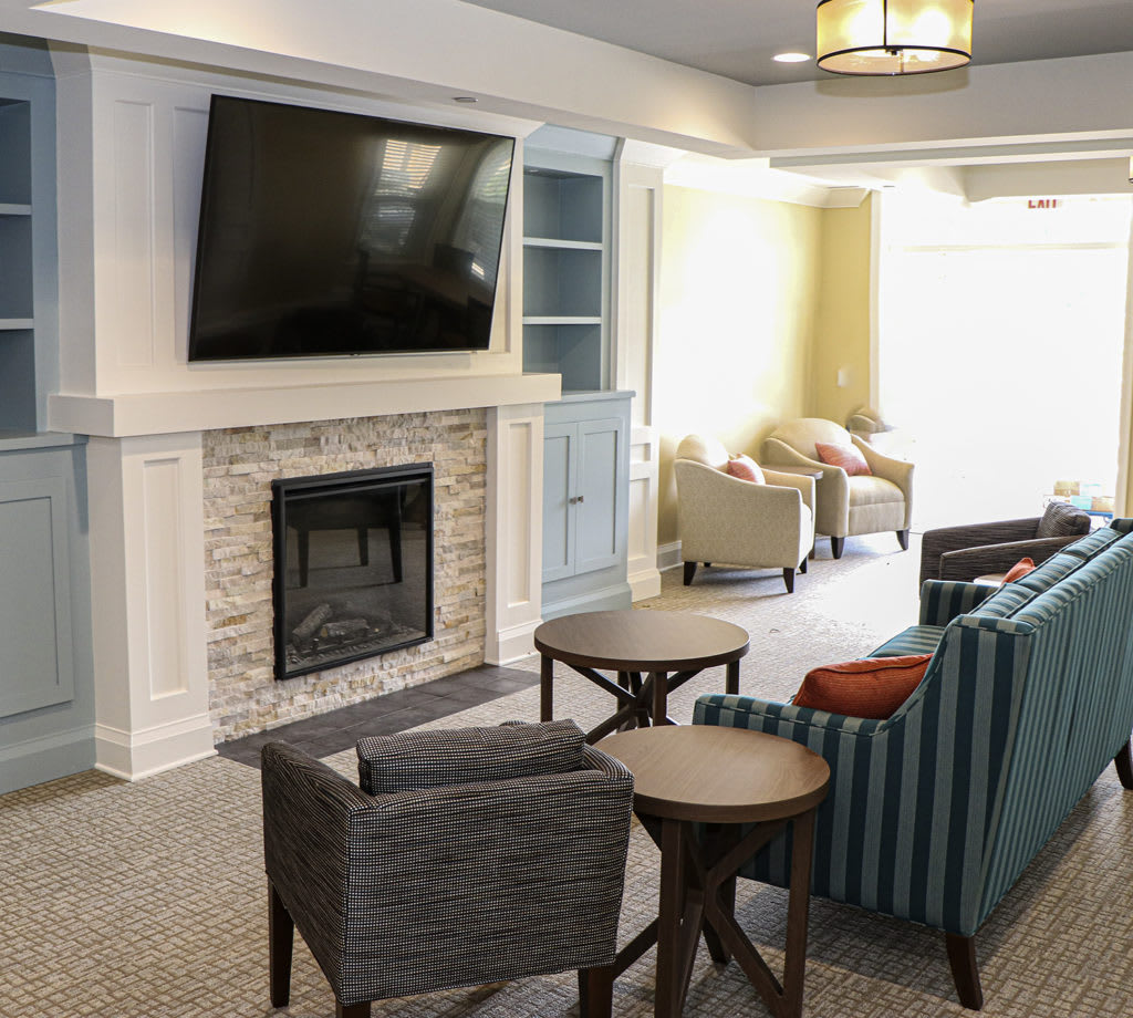A modern living room featuring a fireplace, large television, and comfortable seating.