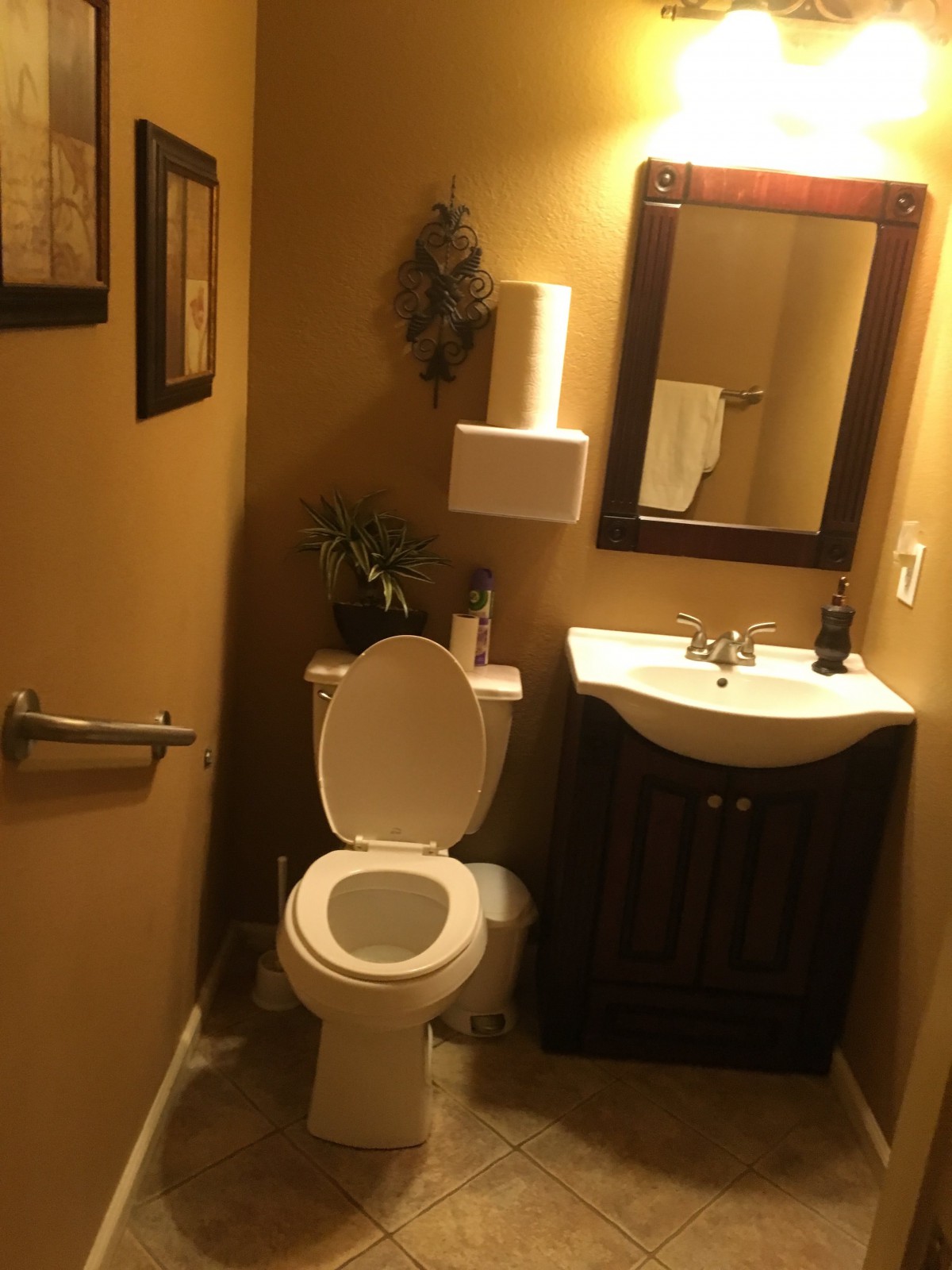 A cozy bathroom with a toilet, sink, and mirror.