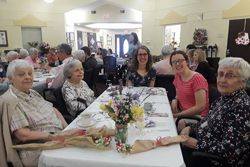 A joyful gathering around a beautifully set table, filled with flowers and surrounded by loved ones.