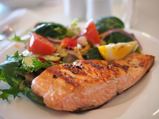 A delicious plate of grilled salmon served with a fresh garden salad.