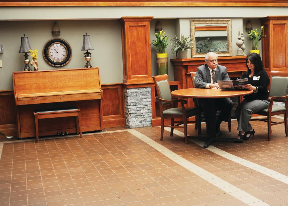 Two individuals sitting at a table in an office setting.