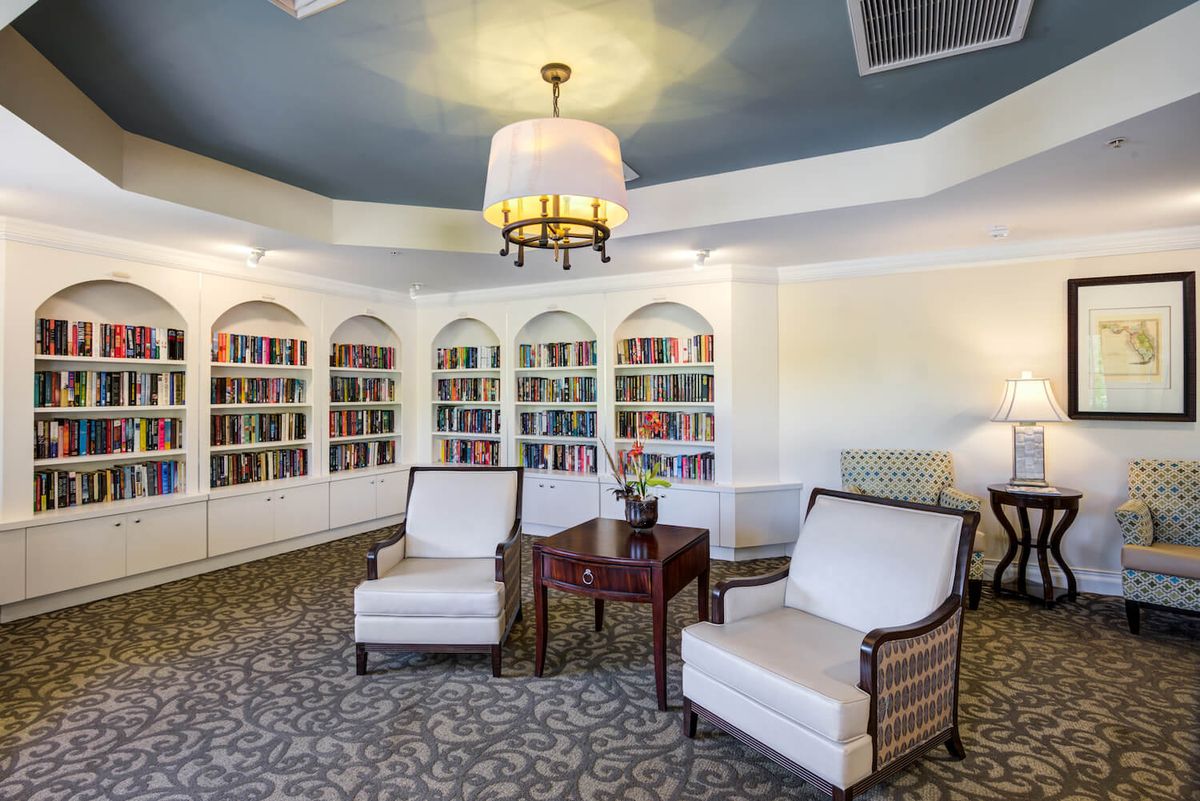 A cozy library corner with armchairs and bookshelves.