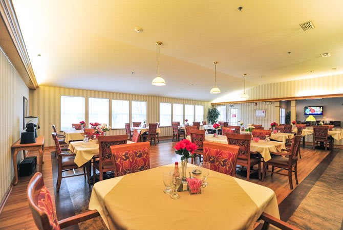 A well-lit dining area with neatly arranged tables and chairs.
