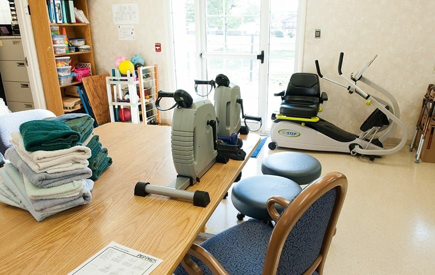 A physical therapy room equipped with exercise machines and seating for rehabilitation.