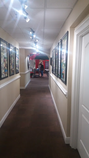 A well-lit hallway adorned with framed artwork on the walls.