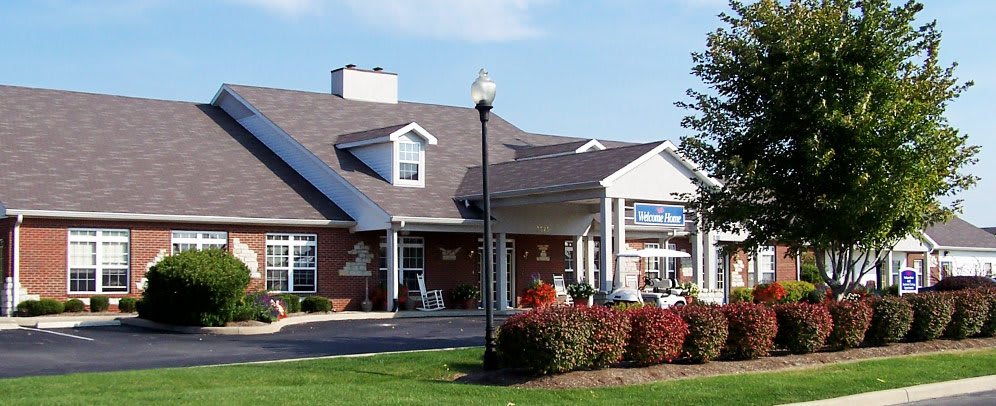 A brick building with a well-maintained front yard and a lamppost.