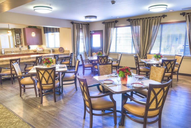 A cozy dining room with elegantly set tables and soft lighting.