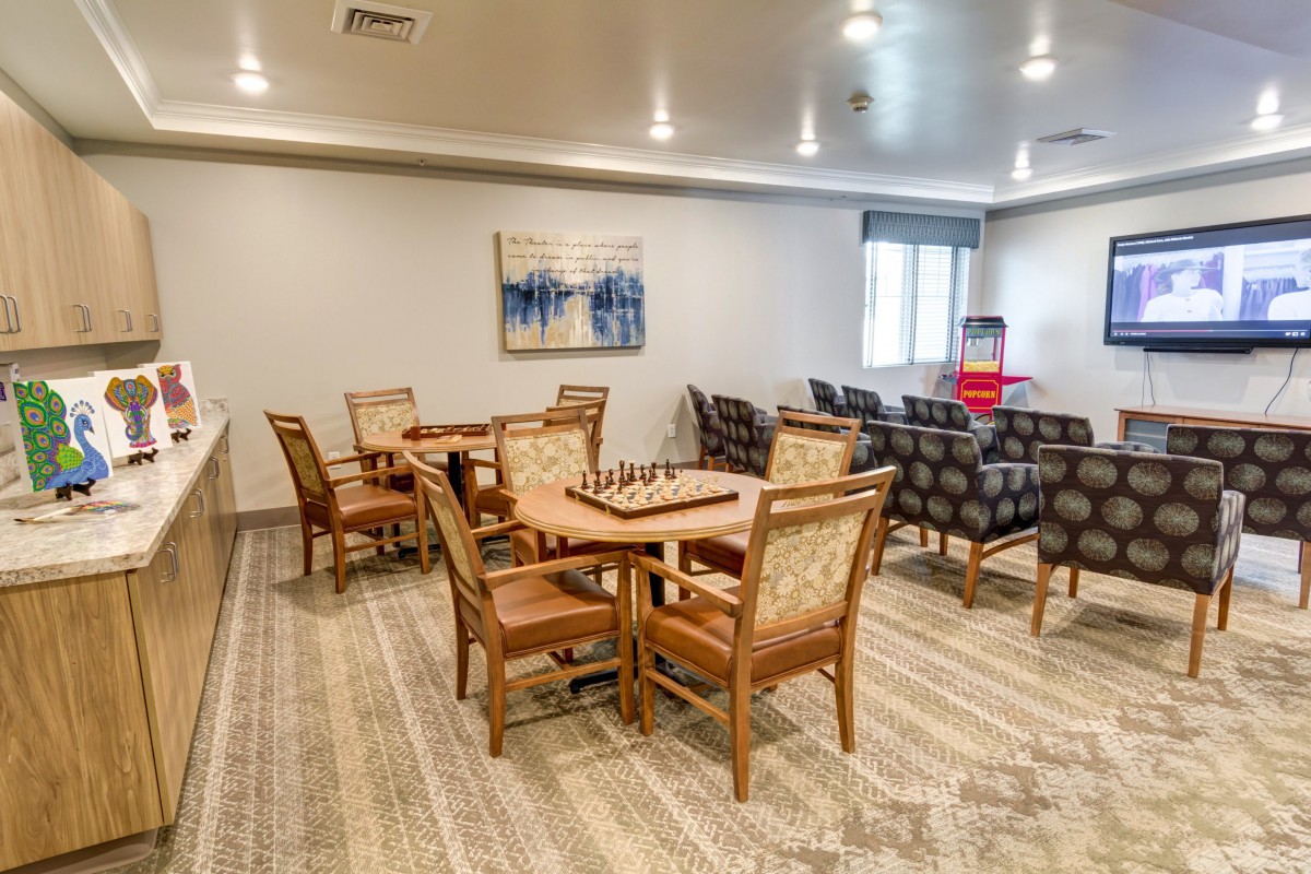 A cozy indoor lounge area with tables, chairs, and a chess set on display.
