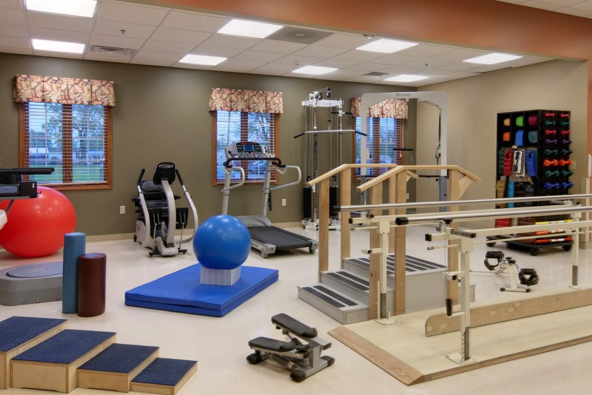 A physical therapy room equipped with various rehabilitation and exercise equipment.