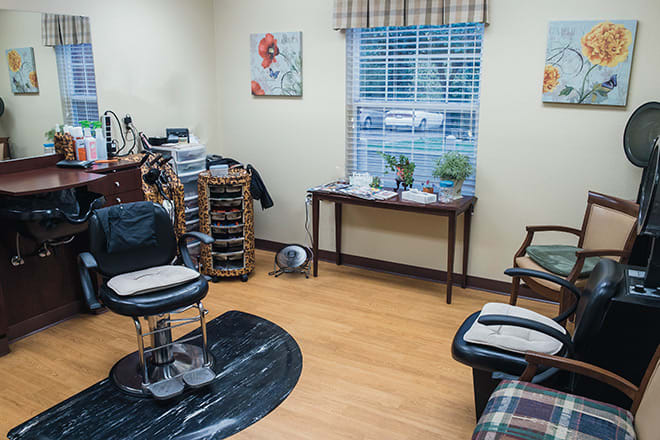 A cozy barbershop interior with chairs and a window view.
