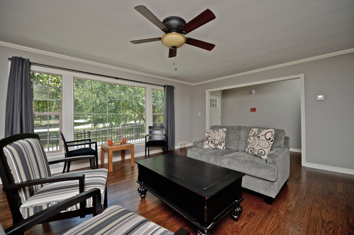 Living room area with hardwood floor and window.