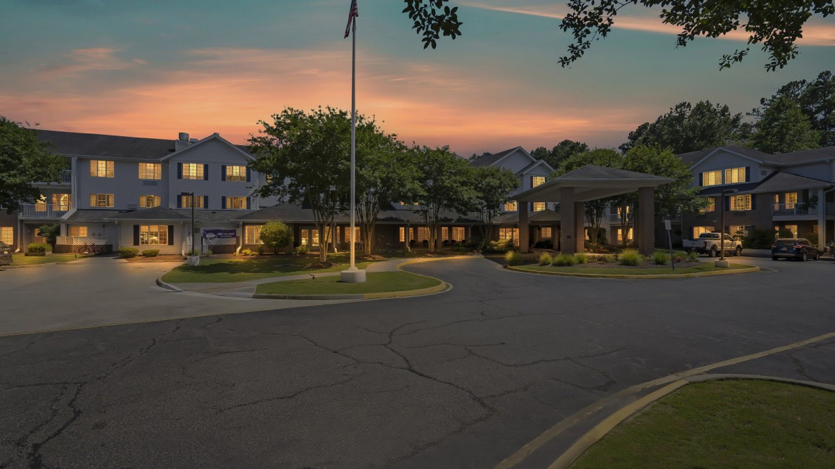 A picturesque view of a building surrounded by trees at sunset.