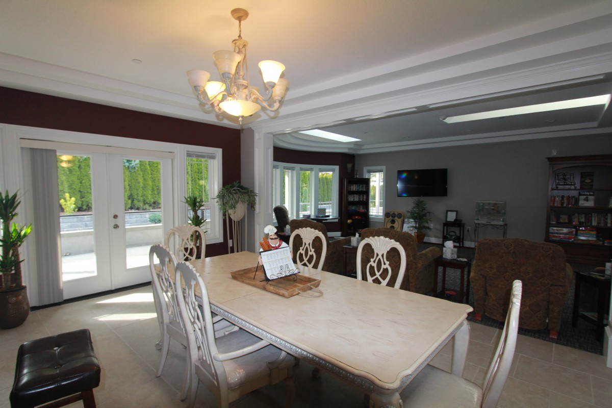 Elegant dining area with a large table and chandelier lighting, featuring a cozy and stylish interior.