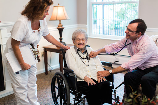A healthcare professional checks on an elderly patient in a nursing home setting, showcasing compassion and care.