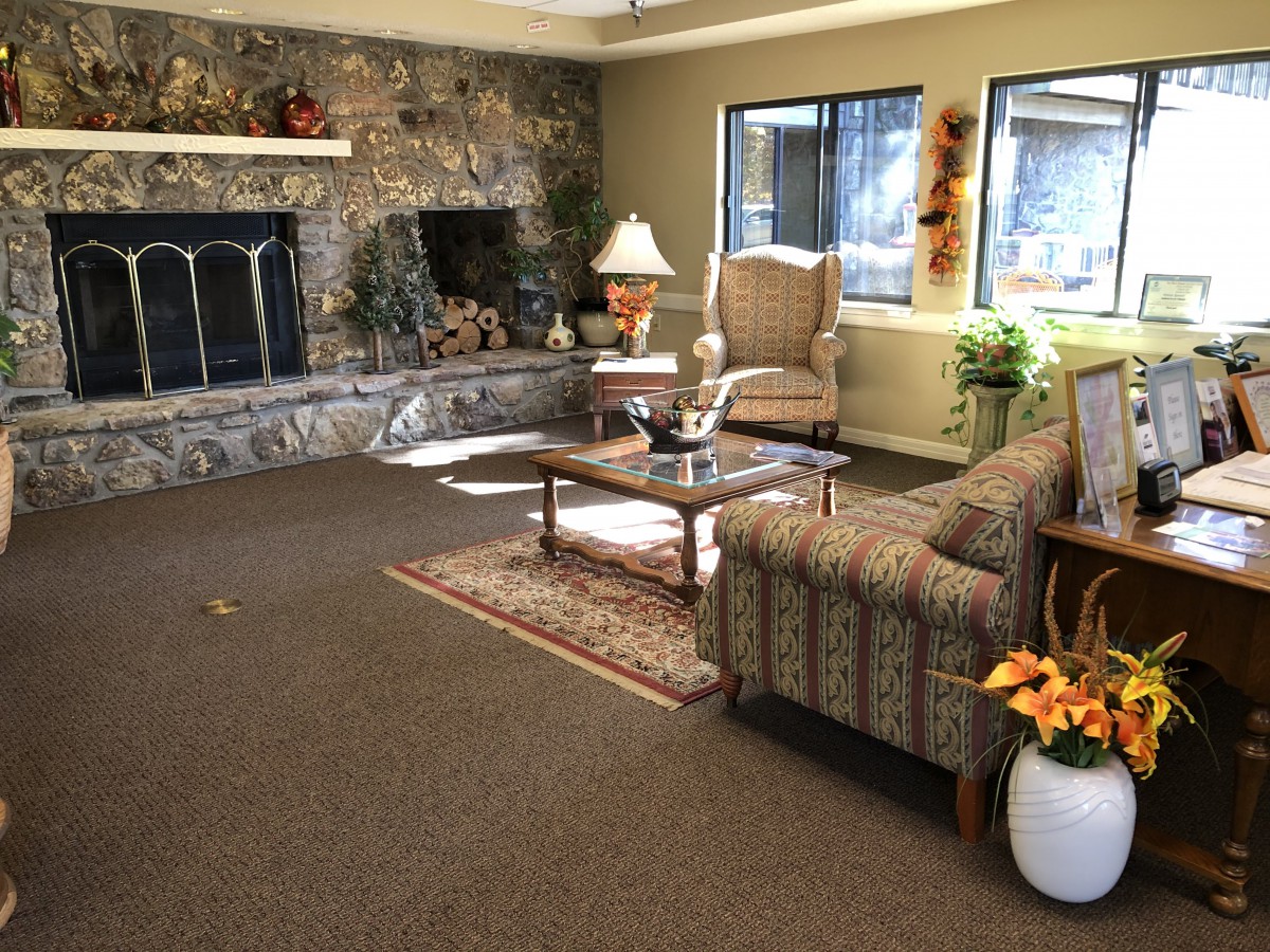 A cozy living room with a stone fireplace and comfortable seating.