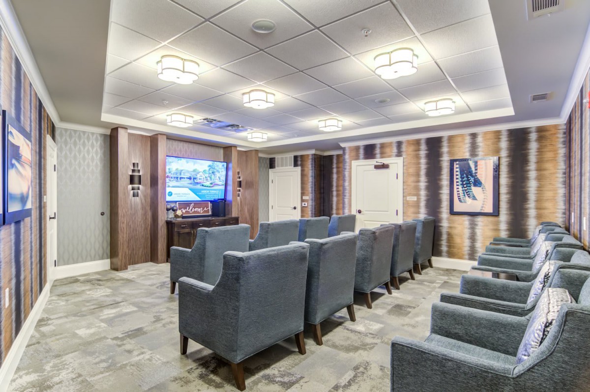 A cozy home theater with plush seating and a large screen.