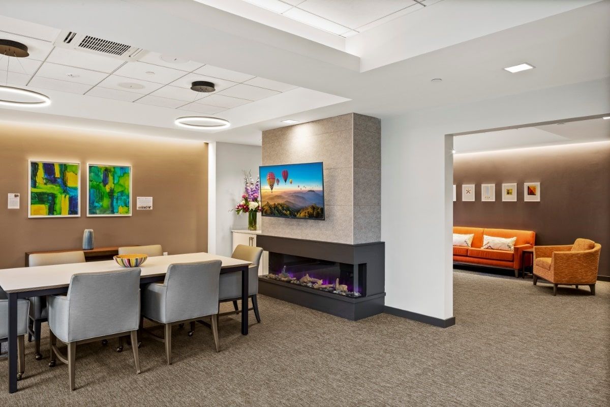 A modern office interior with a conference table and cozy fireplace.