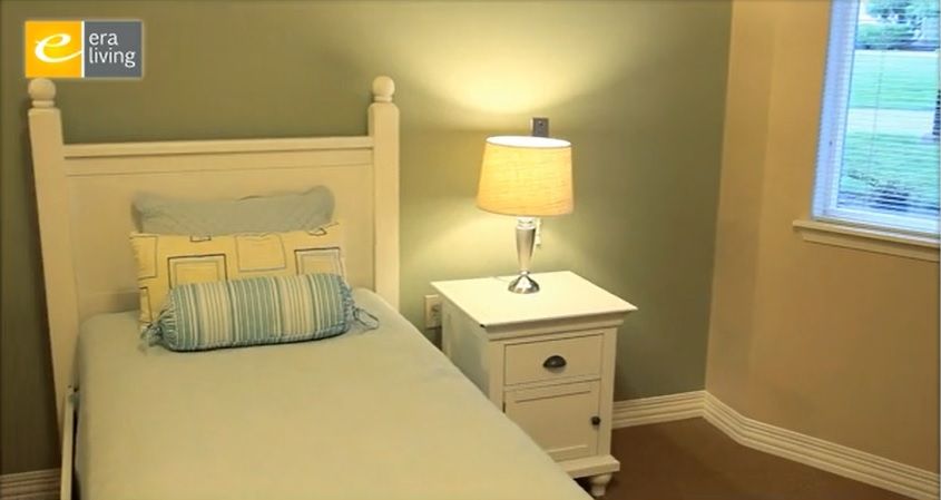 A cozy bedroom with a bedside table and lamp, softly illuminating the serene space.