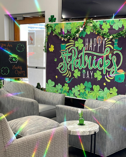 A festive St. Patrick's Day decoration featuring a wall mural adorned with clovers and cheerful greetings.