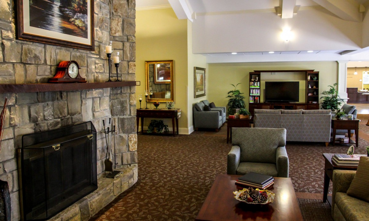 A cozy living room with a stone fireplace and comfortable seating arrangements.