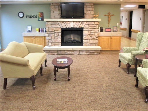 A cozy living room featuring a stone fireplace, comfortable seating, and a television, creating a warm and inviting atmosphere.