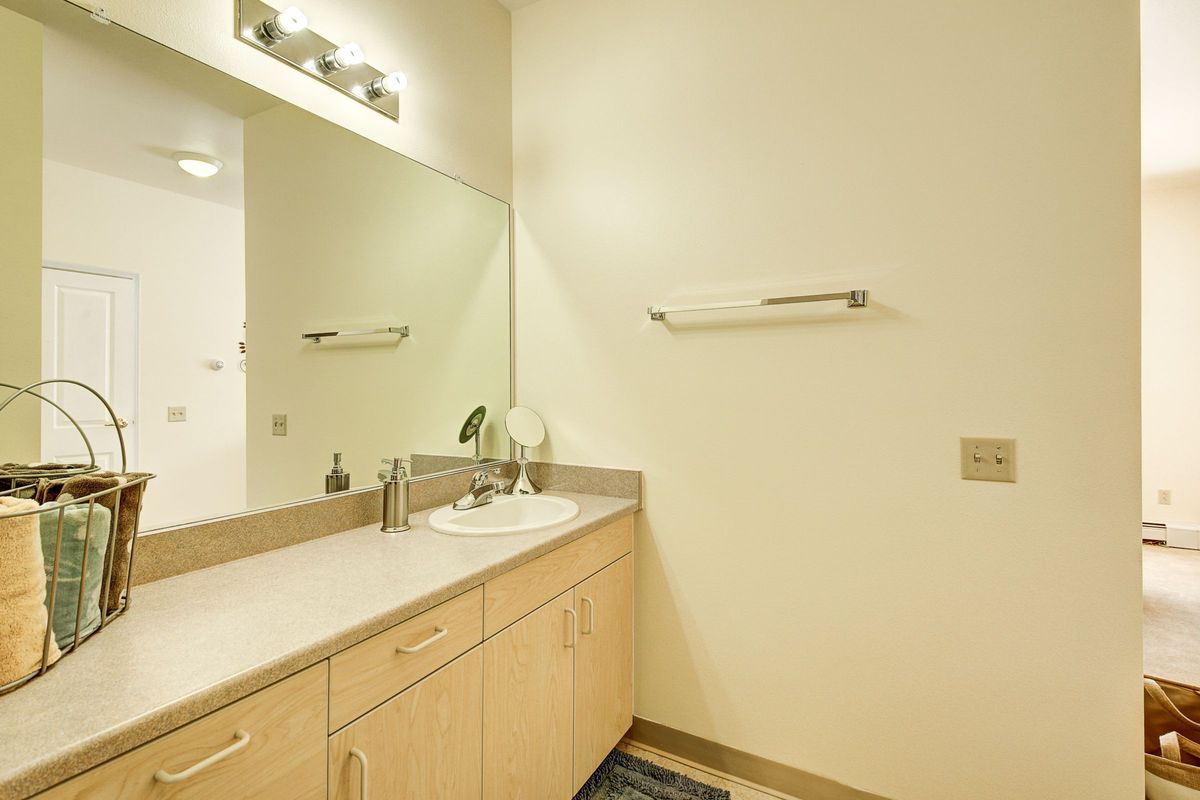 A clean and simple bathroom with a countertop sink and large mirror.