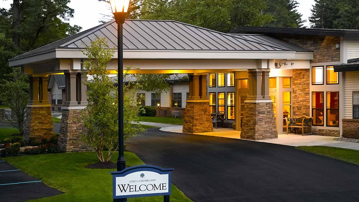 Illuminated entrance to a building with a welcome sign at night.