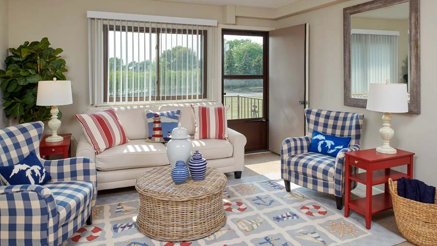 A cozy living room with a sofa, armchair, and rattan coffee table.