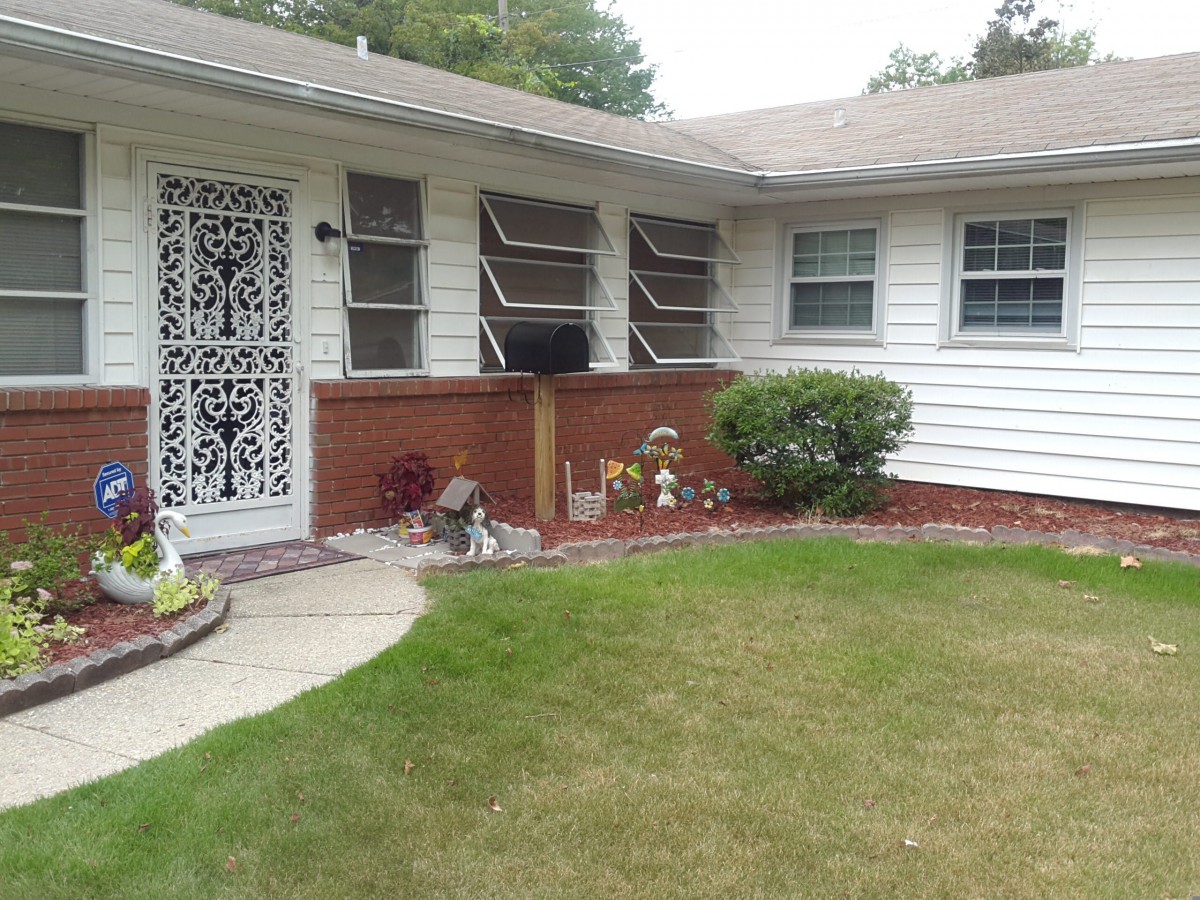 A suburban house with a well-maintained front yard and decorative elements.