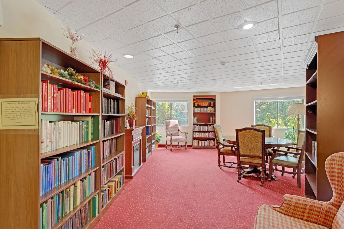 A cozy library room with bookshelves and a reading area.