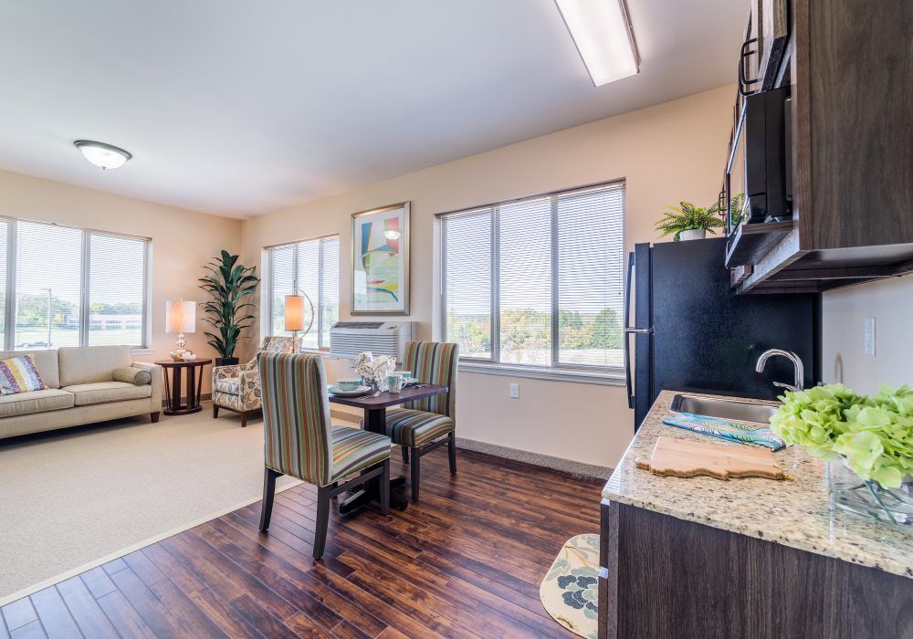 A bright, open-plan kitchen and dining area with hardwood floors and large windows.