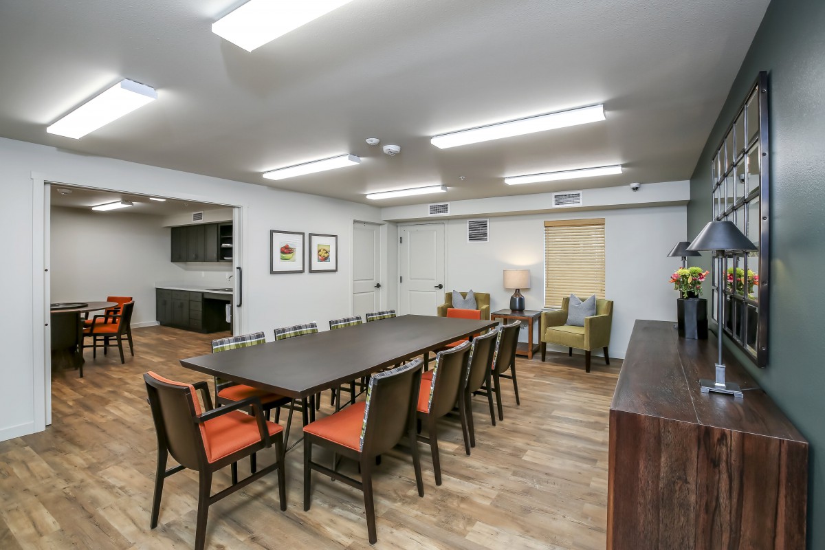 A spacious conference room with a long table, multiple chairs, and modern decor.