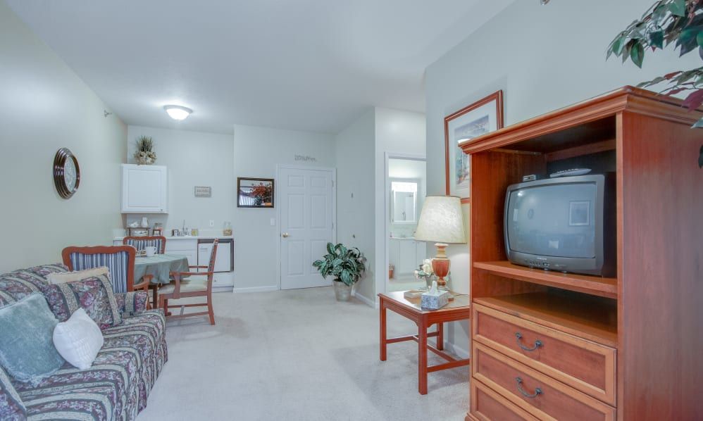A cozy living room with a television, seating area, and various furnishings.