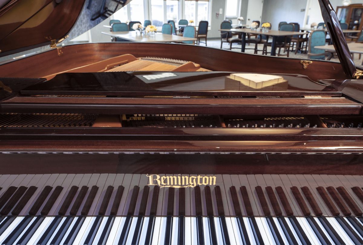 A beautiful grand piano with wooden details, ready for a musical performance.