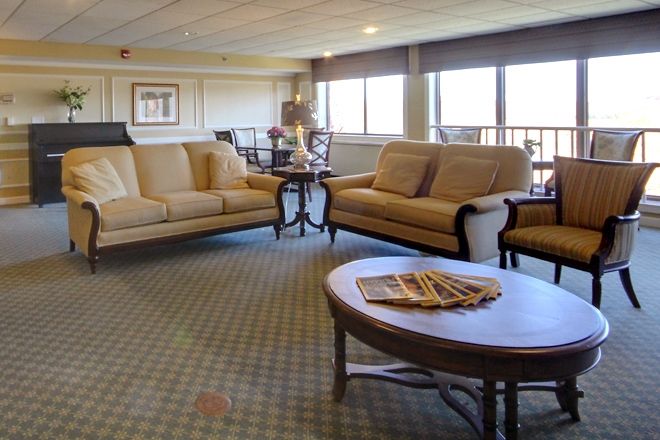 A cozy living room with sofas, a coffee table, and large windows.