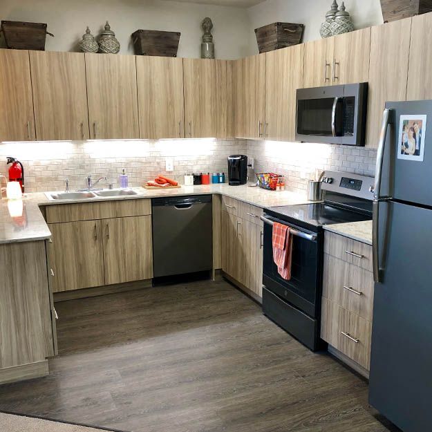 A modern kitchen with wood cabinets and stainless steel appliances.
