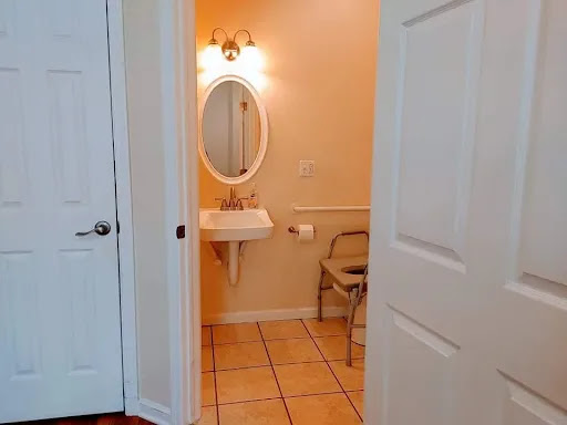 A view of a bathroom featuring a sink, mirror, and tiled floor.