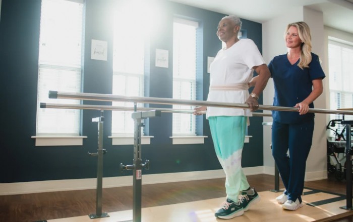 An individual participates in a physical therapy session with the assistance of a therapist.